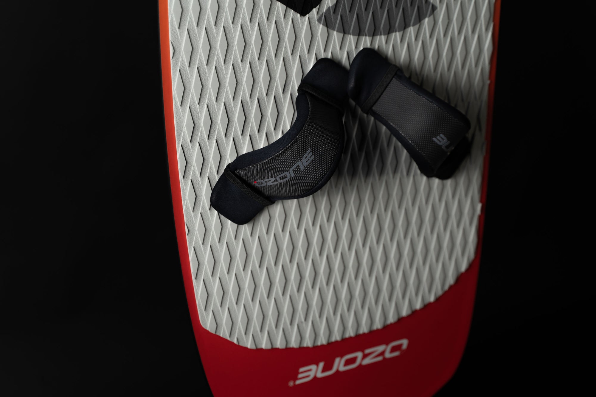 Ozone Apex V1 kitesurfing Board with straps on the board with a black background.
