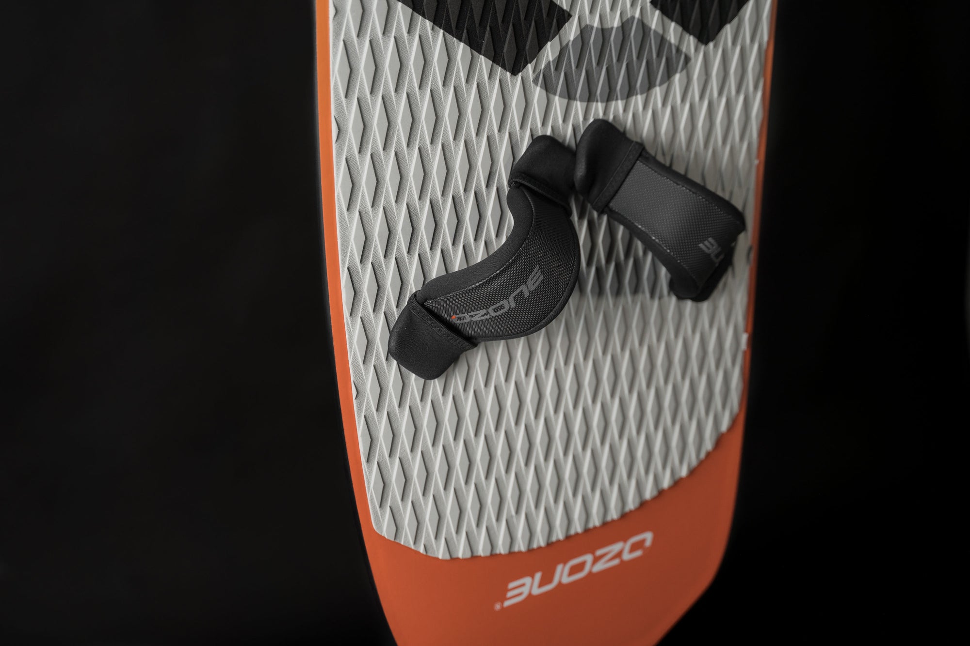 Ozone Apex V1 kitesurfing Board with straps on the board with a black background.