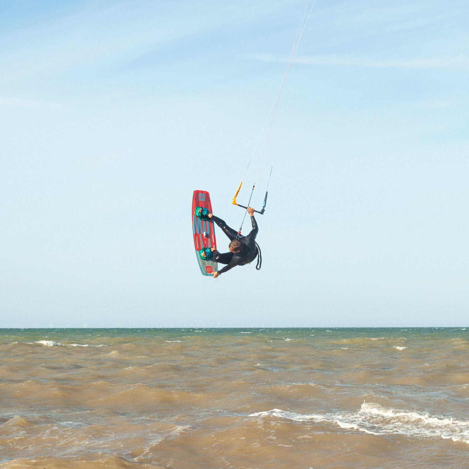 A kitesurfer having a private kitesurfing lesson on how to jump and perform tricks and rotations whilst in the air.