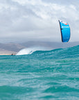 Person catching a wave with a blue Ozone Alpha V2