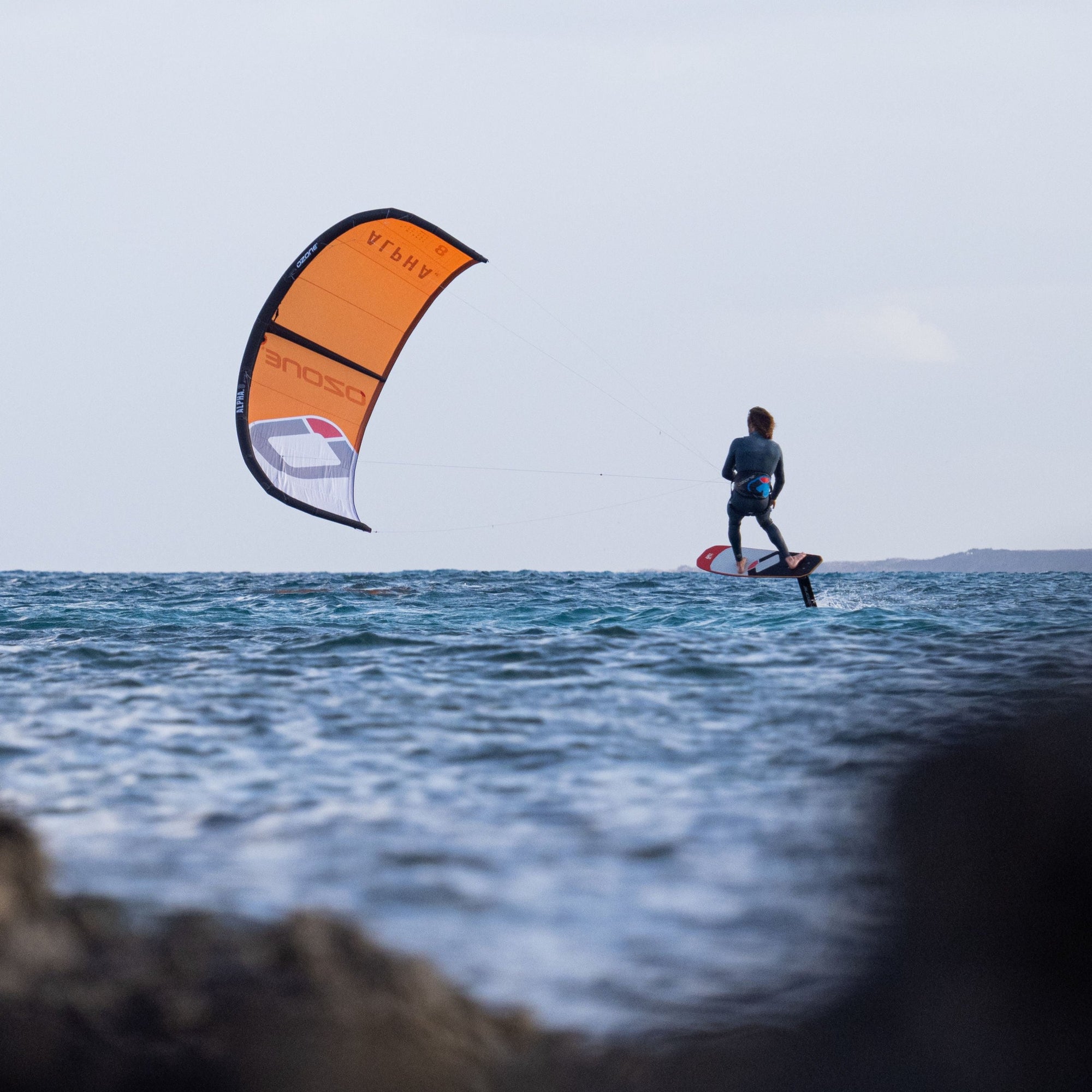 Person foiling with an orange Ozone Alpha V2