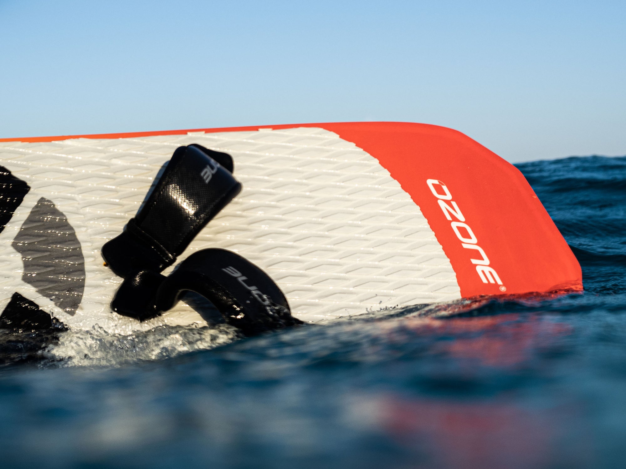 Ozone Apex V1 kitesurfing foil board in the water with straps on.